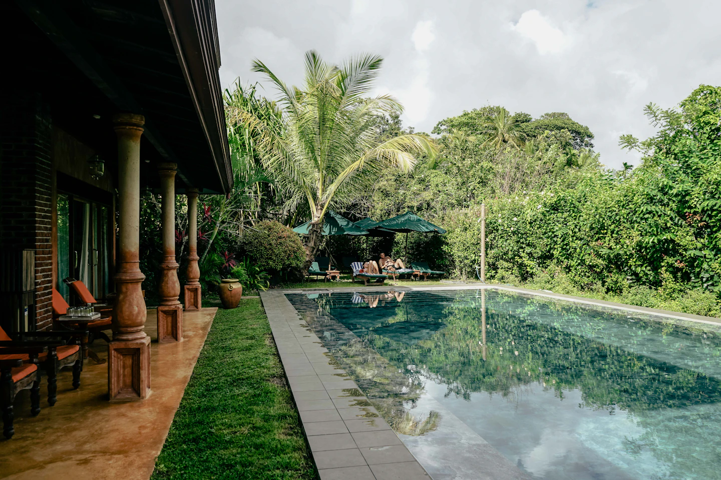 Guests relaxing beside a tropical hotel pool in Mirissa, Sri Lanka